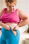 Overweight woman squeezing into small pants