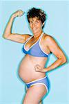 Pregnant woman in bikini showing muscles