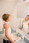 Boy making faces in bathroom mirror