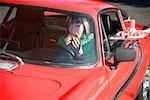 Woman eagerly eating sandwich at drive-in