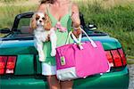 Woman holding dog outside car