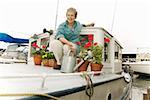 Frau auf Hausboot mit Pflanzen