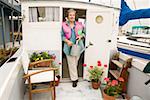 Woman on houseboat watering plants