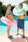 Pregnant couple at pool with inner tubes