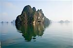 Rocky islands with still water in misty morning