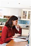 Woman using laptop computer in kitchen
