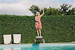 Elderly woman dancing on diving board