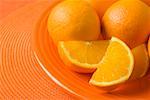 Closeup of oranges and orange slices on plate