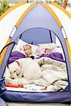 Jeunes filles dormir sous tente avec chien
