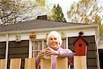 Portrait of senior woman behind fence