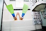 Pacific Islander, Asian woman wearing flippers in bathtub