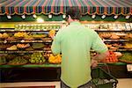 Man selecting produce in supermarket