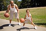 Father and son dribbling basketballs