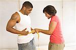 Woman measuring husband’s waist