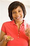 Woman taking handful of pills