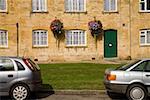 Cars parked outside stone cottages, Cotswolds, United Kingdom