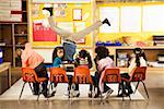 Male teacher doing handstand in classroom