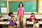 Portrait of female teacher and students in classroom