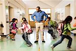 Blurred motion shot of students running past teacher