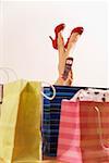 Woman dialing cell phone next to shopping bags