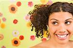 Woman looking sideways in front of flower background