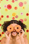 Woman holding flowers over eyes