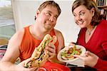 Woman offering her husband a salad instead of sandwich