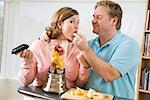 Couple, manger des fruits tout en faisant un smoothie