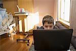 Kleiner Junge mit einem Laptop im Krankenzimmer