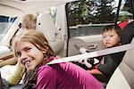 Young girl leaning forward in backseat of car
