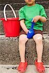 Young boy holding shovel and bucket