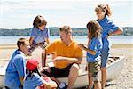 Male camp counselor with children at beach