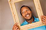 African man looking through picture frame