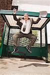 Businessman jumping at bus stop