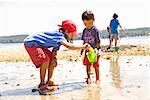 Asiatische Schwester und Bruder spielen am Strand