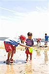 Asiatische Schwester und Bruder spielen am Strand