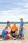 Male camp counselor and children at beach