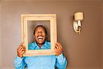 African man looking through picture frame