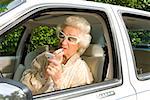 Senior Woman Lippenstift in Auto anwenden