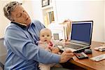 Businessman working with baby on lap