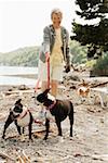 Senior woman walking dogs on beach