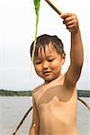 Boy holding stick with seaweed