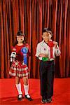 Asian girl and boy holding prize ribbons on stage