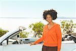 African woman next to convertible car