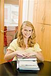 Teenage girl with stack of school books