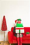Woman sitting with stack of Christmas gifts