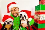 African man an dogs wearing Santa Claus hats