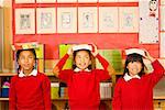 Multi-ethnic girl balancing school books on heads