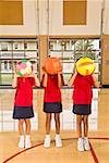 Multi-ethnic girls holding sports balls