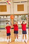 Multi-ethnic girls throwing sports balls